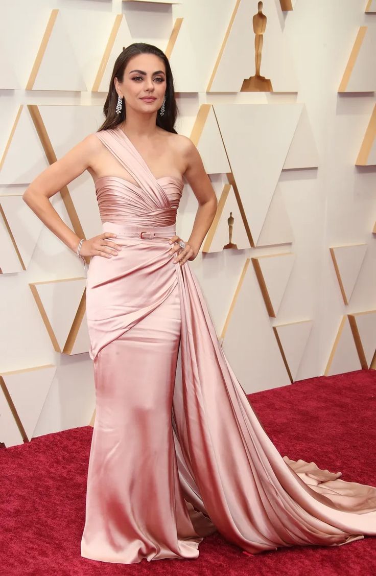 Mila Kunis in a white dress at a 2025 movie premiere smiling for the cameras